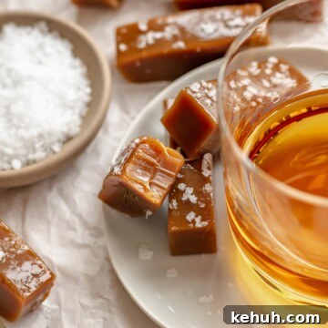 Salted caramels on a plate next to a glass of whiskey.