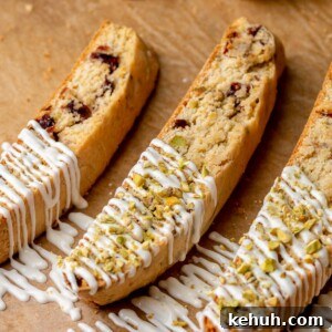Three pieces of biscotti with white chocolate drizzled on top.
