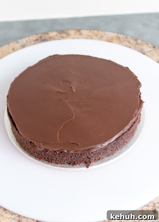 How to Cover a Cake with Smooth Ganache Finish 8 One cake layer spread with dark chocolate ganache.
