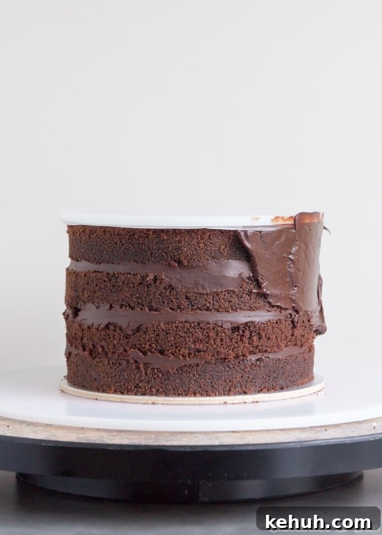 How to Cover a Cake with Smooth Ganache Finish 10 Ganache being spread around the sides of the cake.