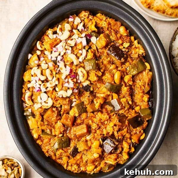 Vegetarian slow cooker curry in a slow cooker topped with cashew nuts.
