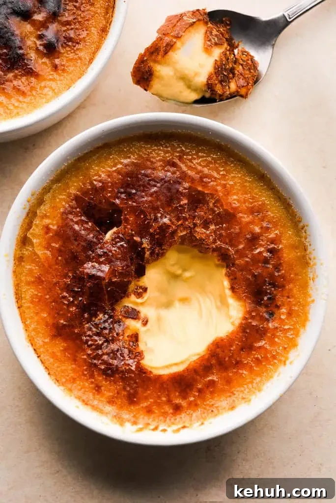 fall creme brulee Pumpkin creme brulee with a caramelized top, partially eaten to reveal the creamy pumpkin custard inside.