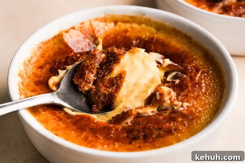 Pumpkin Creme Brulee Pumpkin creme brulee with a caramelized top, showing a spoon lifting a portion of the smooth, spiced custard