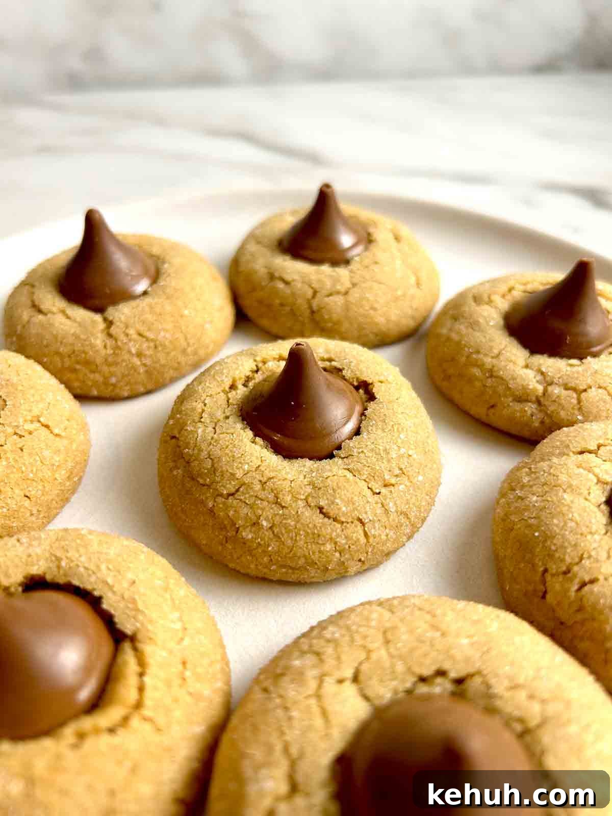Classic Peanut Butter Blossom Cookies: Soft Chocolate Kiss Treats 2 close up of peanut butter blossom cookies on plate.