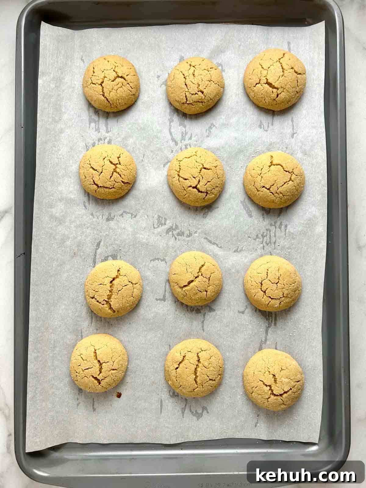 Classic Peanut Butter Blossom Cookies: Soft Chocolate Kiss Treats 9 cookies after baking; tops cracked and cookies are puffed.