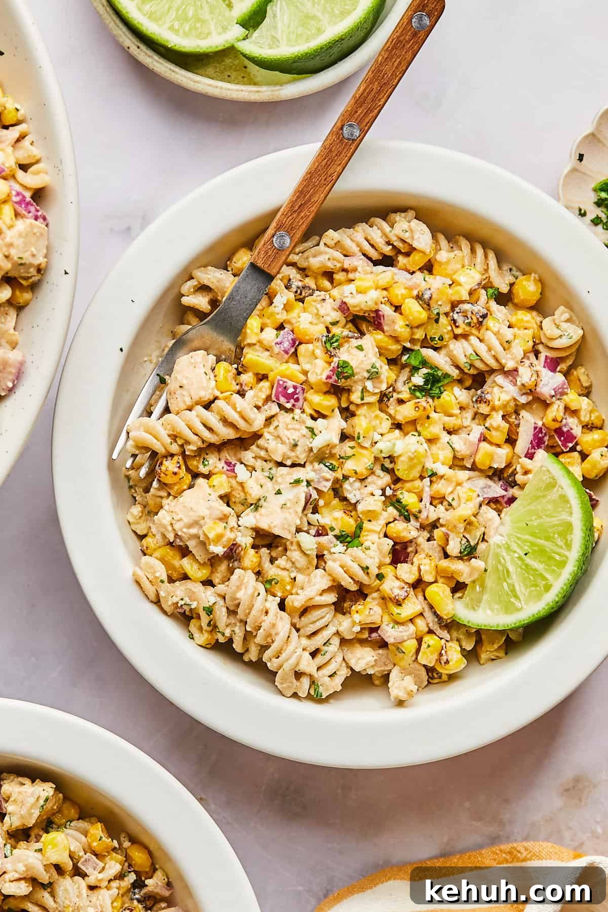 street corn pasta salad in a while bowl with a wooden fork