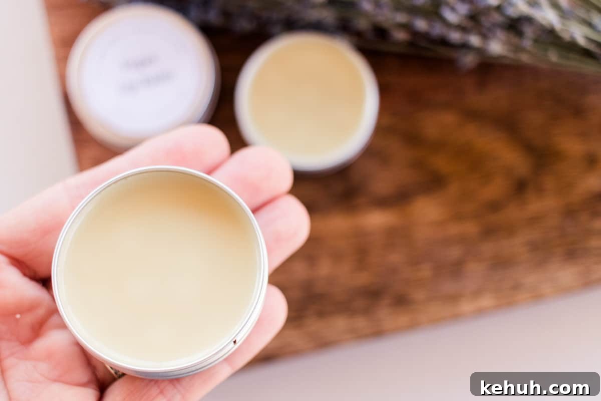 Holding a small tin of lip balm.