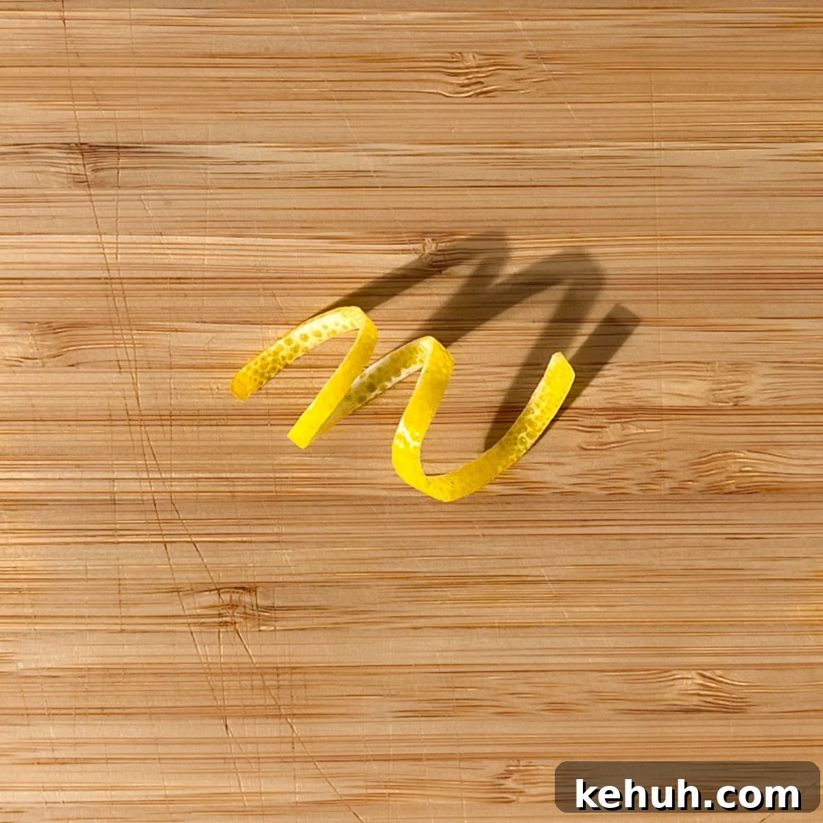 Classic Rock Shandy Recipe: Refreshing Lemon Beer Cocktail 12 A lemon peel twisty on a wooden chopping board.