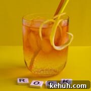 Classic Rock Shandy Recipe: Refreshing Lemon Beer Cocktail 13 A medium glass of Rock shandy on a yellow background with an orange and yellow straw.