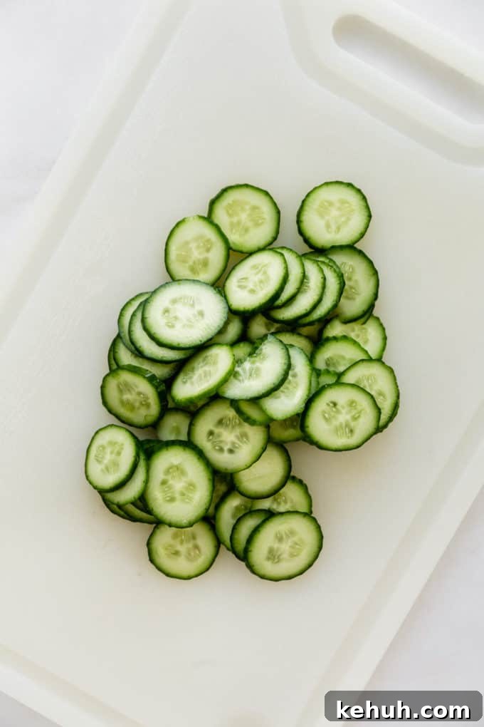 Quick Asian Cucumber Salad Ready in 10 Minutes 5 sliced cucumbers on a white cutting board