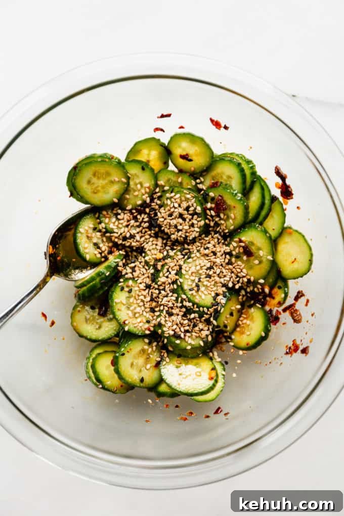 Quick Asian Cucumber Salad Ready in 10 Minutes 9 Asian cucumber salad in a mixing bowl topped with sesame seeds