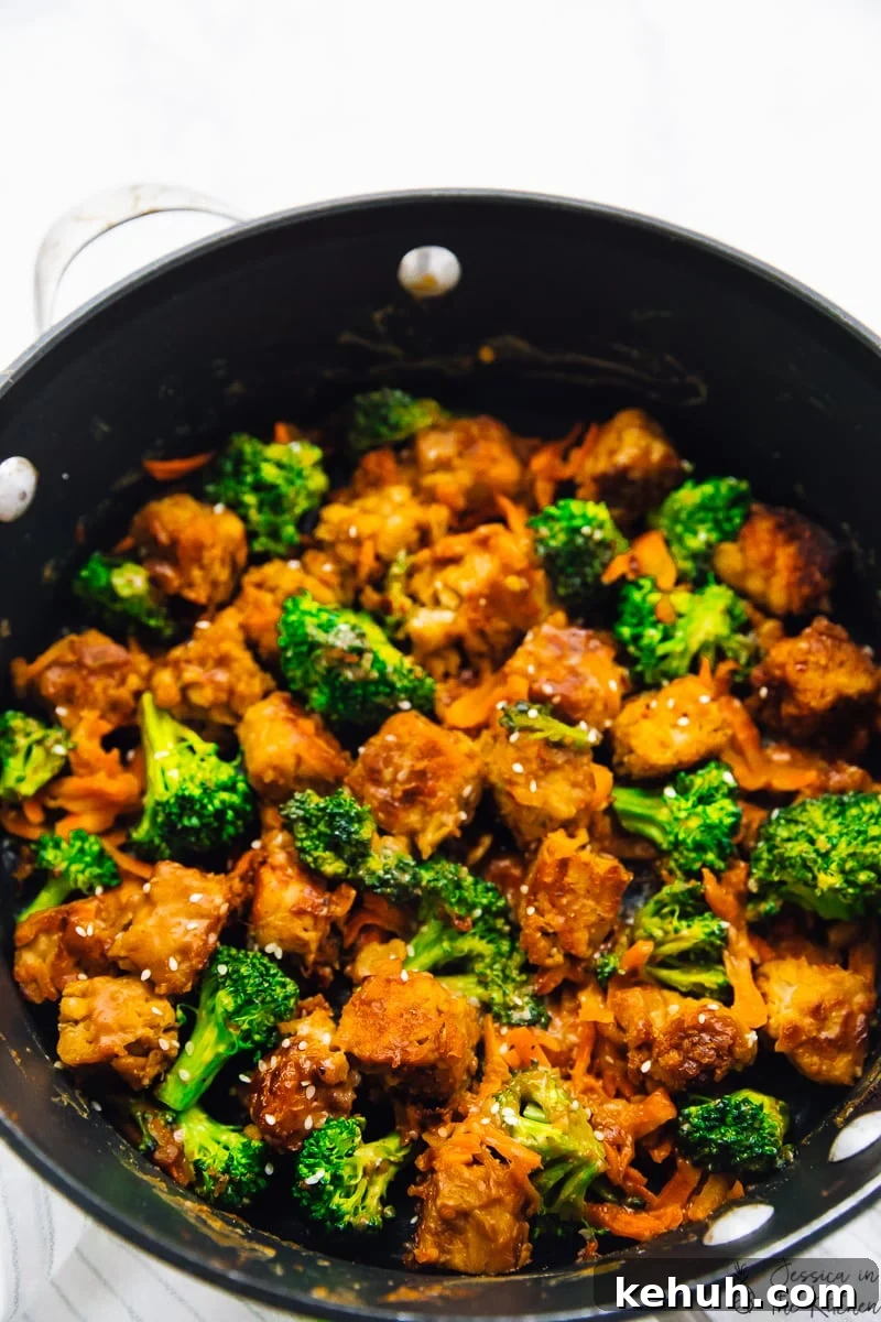 Overhead shot of tempeh stir fry in a black skillet. 