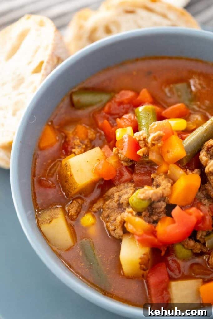 Hearty Ground Beef and Vegetable Soup Recipe 4 close up of blue bowl with vegetable hamburger soup