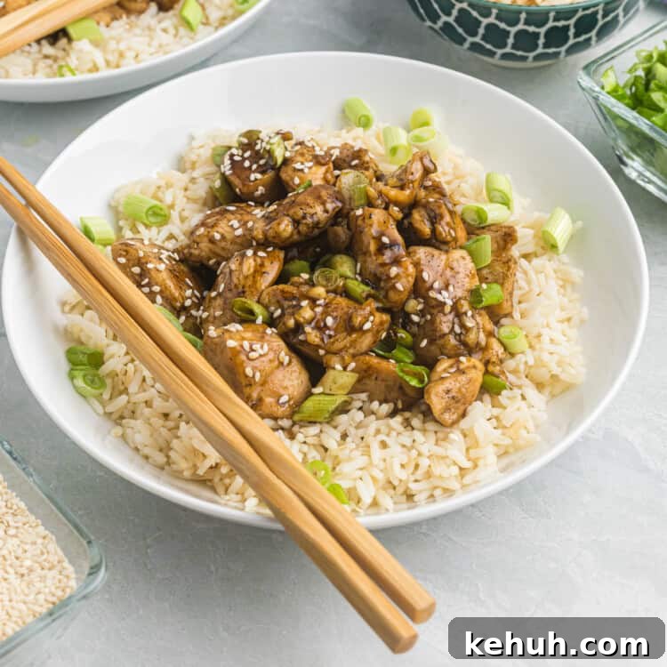 Blackstone Teriyaki Chicken in a bowl over rice with chopsticks