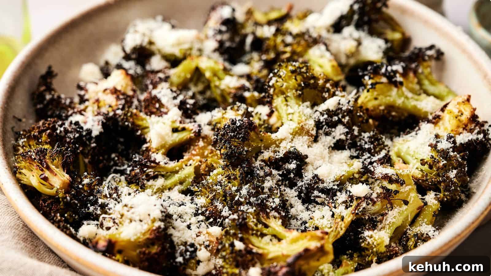 31 Homemade Thanksgiving Sides That Outshine Store-Bought 20 A bowl of roasted broccoli topped with grated cheese and seasoning.