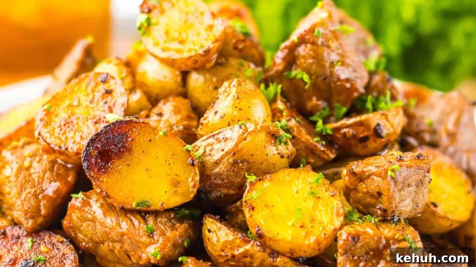 31 Homemade Thanksgiving Sides That Outshine Store-Bought 29 A close-up image of honey chipotle seasoned roasted potatoes garnished with parsley, served alongside grilled steak and lettuce.