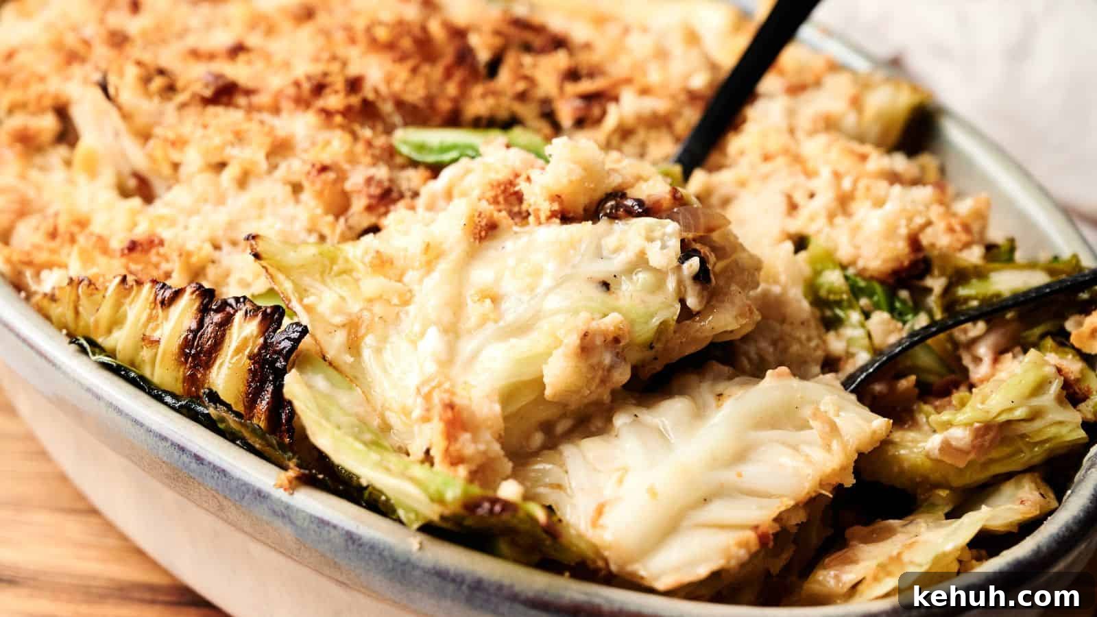 31 Homemade Thanksgiving Sides That Outshine Store-Bought 7 A close-up of a baked casserole dish filled with creamy cabbage gratin, topped with a golden breadcrumb crust, with a serving spoon partially visible.