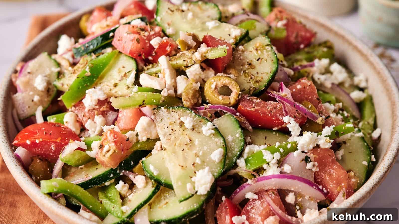 31 Homemade Thanksgiving Sides That Outshine Store-Bought 8 A bowl of Greek salad with sliced cucumbers, tomatoes, red onions, green bell peppers, olives, and crumbled feta cheese.