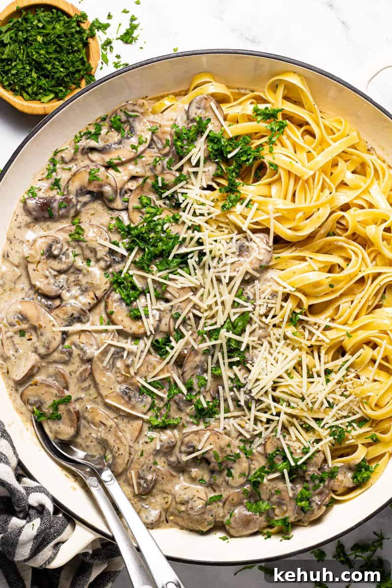 Vegan Mushroom Stroganoff Without Cashew Cream or Roux 9 Large white pan filled with vegan mushroom stroganoff garnished with fresh chopped parsley
