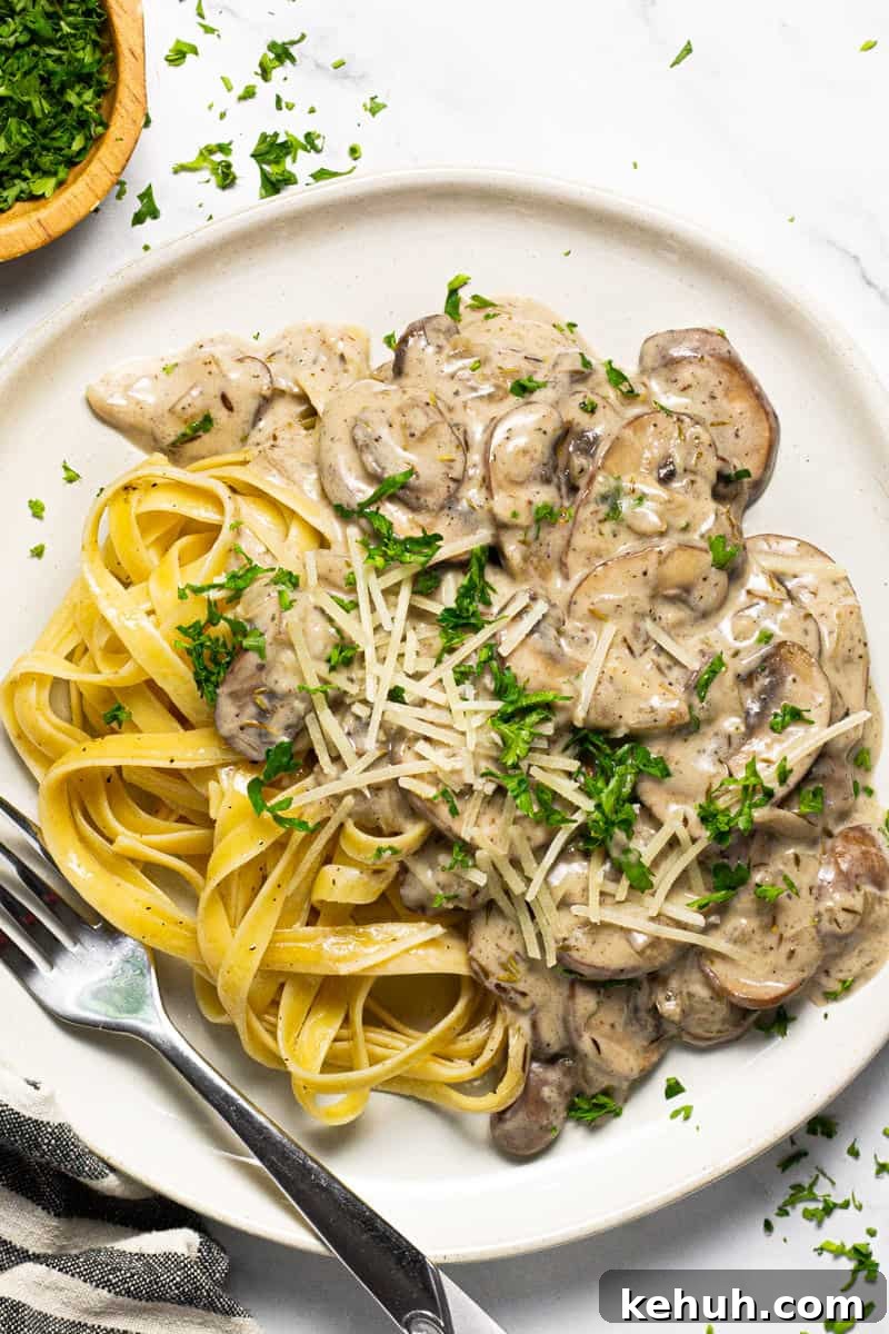 Vegan Mushroom Stroganoff Without Cashew Cream or Roux 3 White plate with vegan stroganoff and fettuccine noodles garnished with parsley