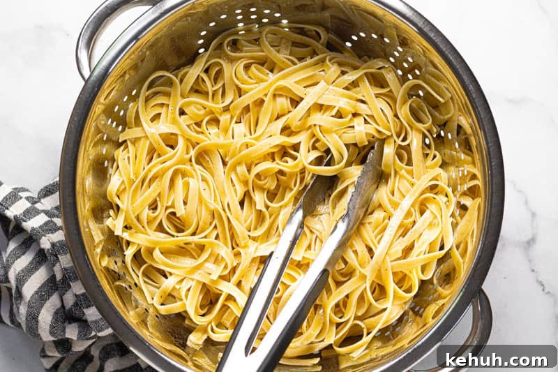 Vegan Mushroom Stroganoff Without Cashew Cream or Roux 4 metal strainer with al dente fettuccine noodles