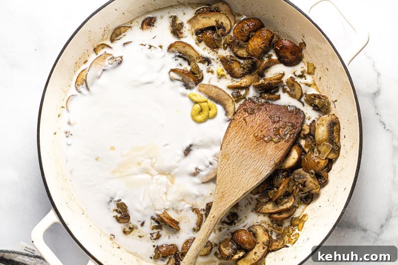 Vegan Mushroom Stroganoff Without Cashew Cream or Roux 7 Large white pan with sauteed mushrooms coconut milk and Dijon mustard