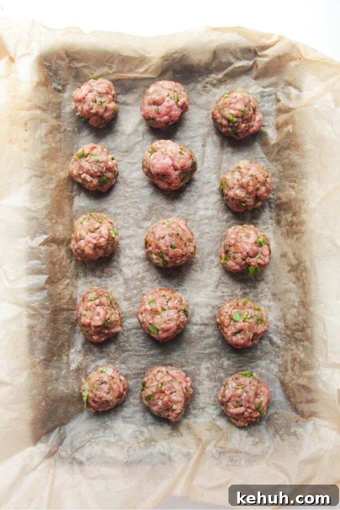 Festive Mini Meatballs Recipe for Holiday Appetizers 6 Rolled meatballs on a lined oven tray.