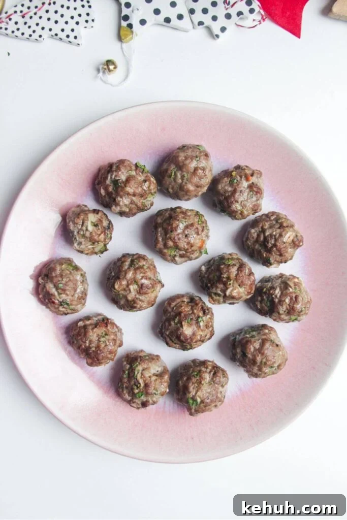 Festive Mini Meatballs Recipe for Holiday Appetizers 8 Cooked meatballs on a small pink plate.