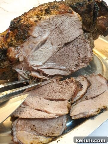 A roasted leg of lamb being carved into slices.
