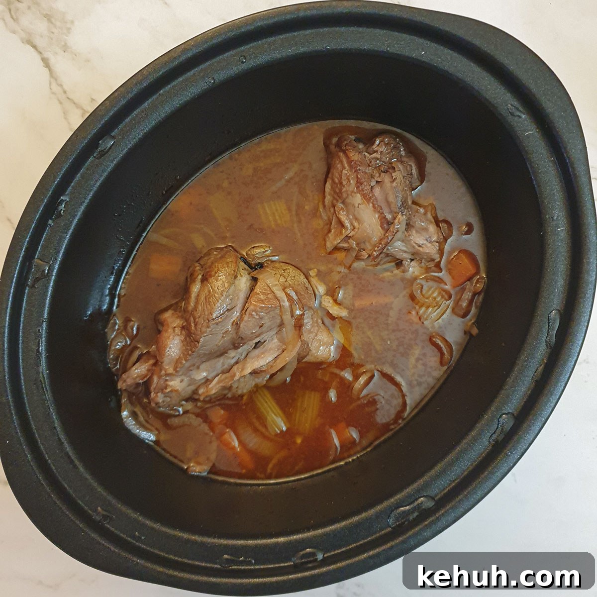 Cooked lamb shanks in a slow-cooker.