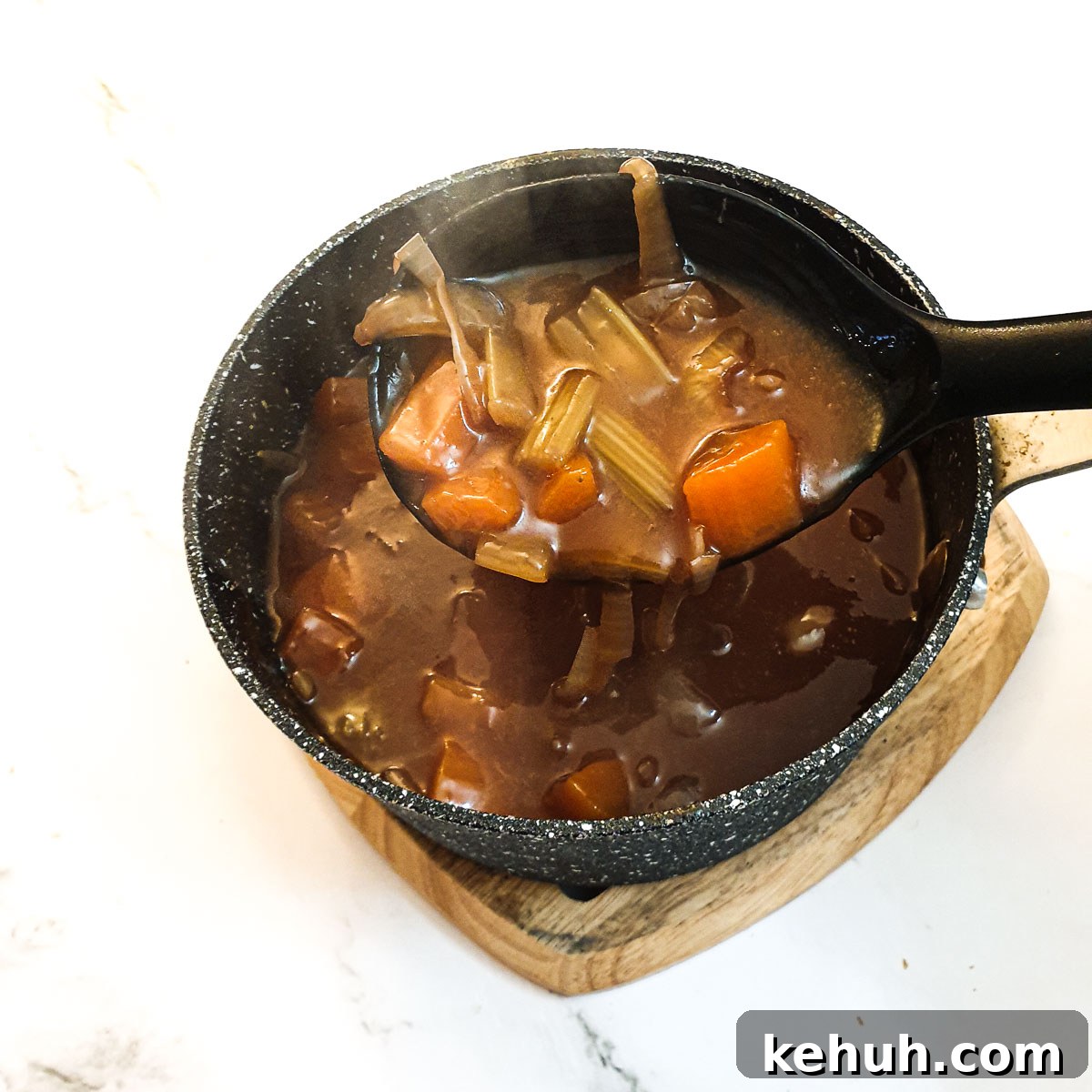 A saucepan containing the vegetables and gravy before being thickened.