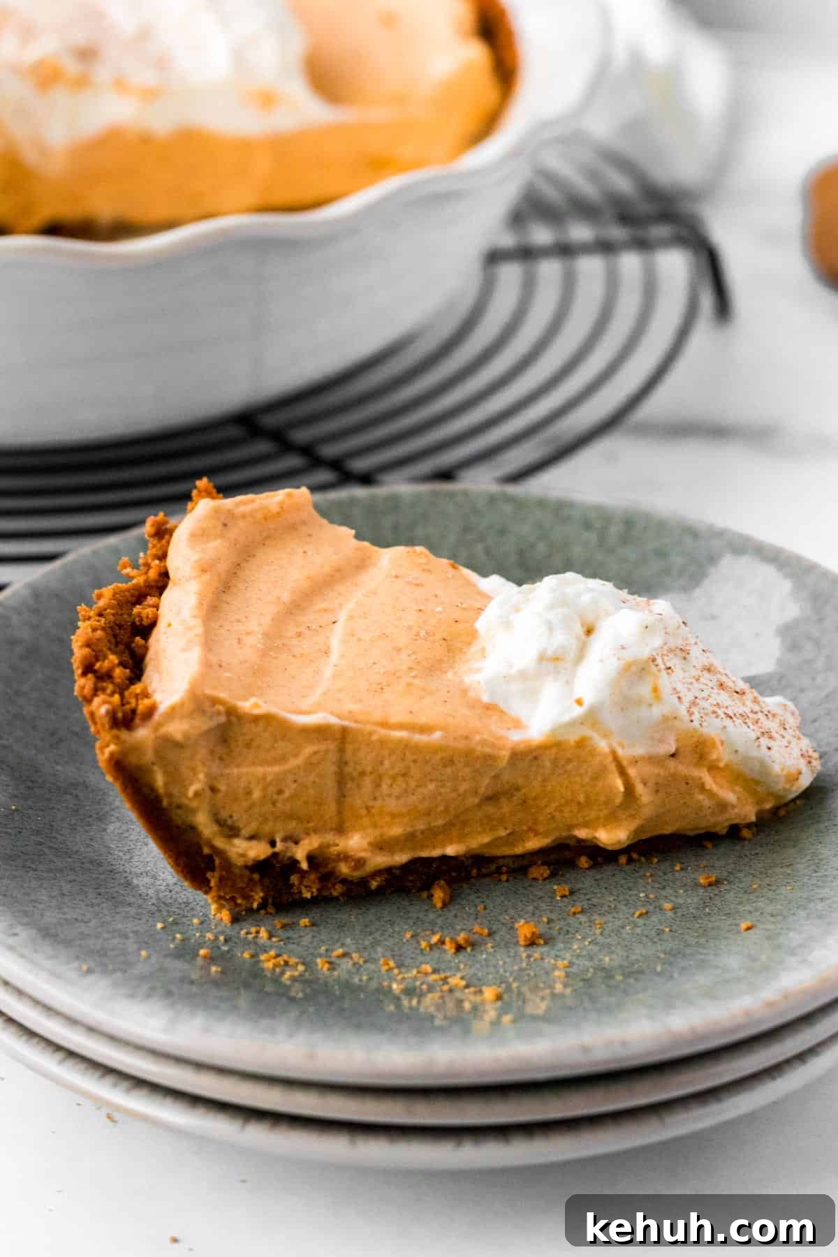 Pumpkin Mousse Pie with Gingersnap Crust — Creamy Fall Dessert 4 slice of pumpkin mousse pie on stack of plates with full pie in background