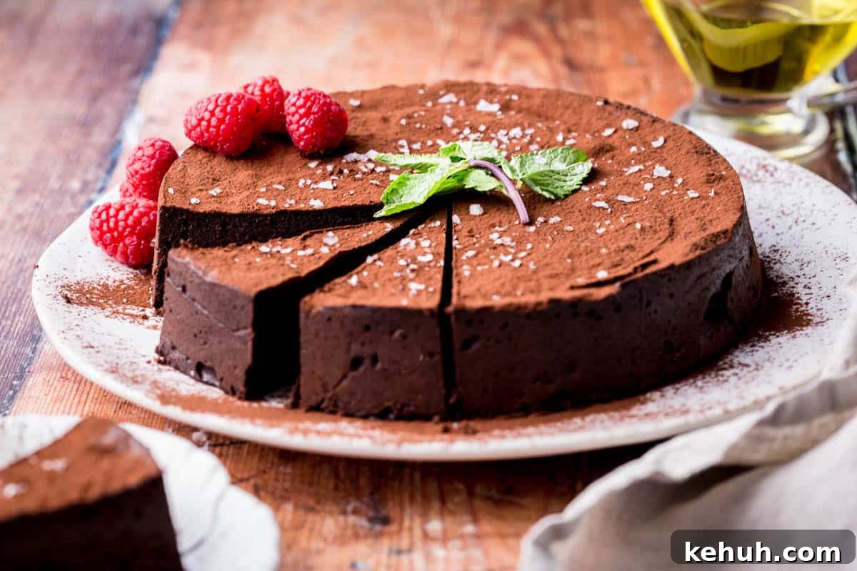 Olive Oil Chocolate Cake (Flourless, Rich & Decadent) 15 Sliced Flourless Olive Oil Chocolate Cake dusted with cocoa powder, sprinkled with flaky sea salt and decorated with a mint leaf and raspberries.