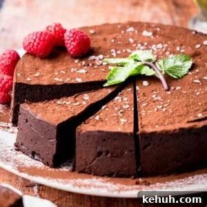 Olive Oil Chocolate Cake (Flourless, Rich & Decadent) 17 Sliced Flourless Olive Oil Chocolate Cake dusted with cocoa powder, sprinkled with flaky sea salt and decorated with a mint leaf and raspberries.
