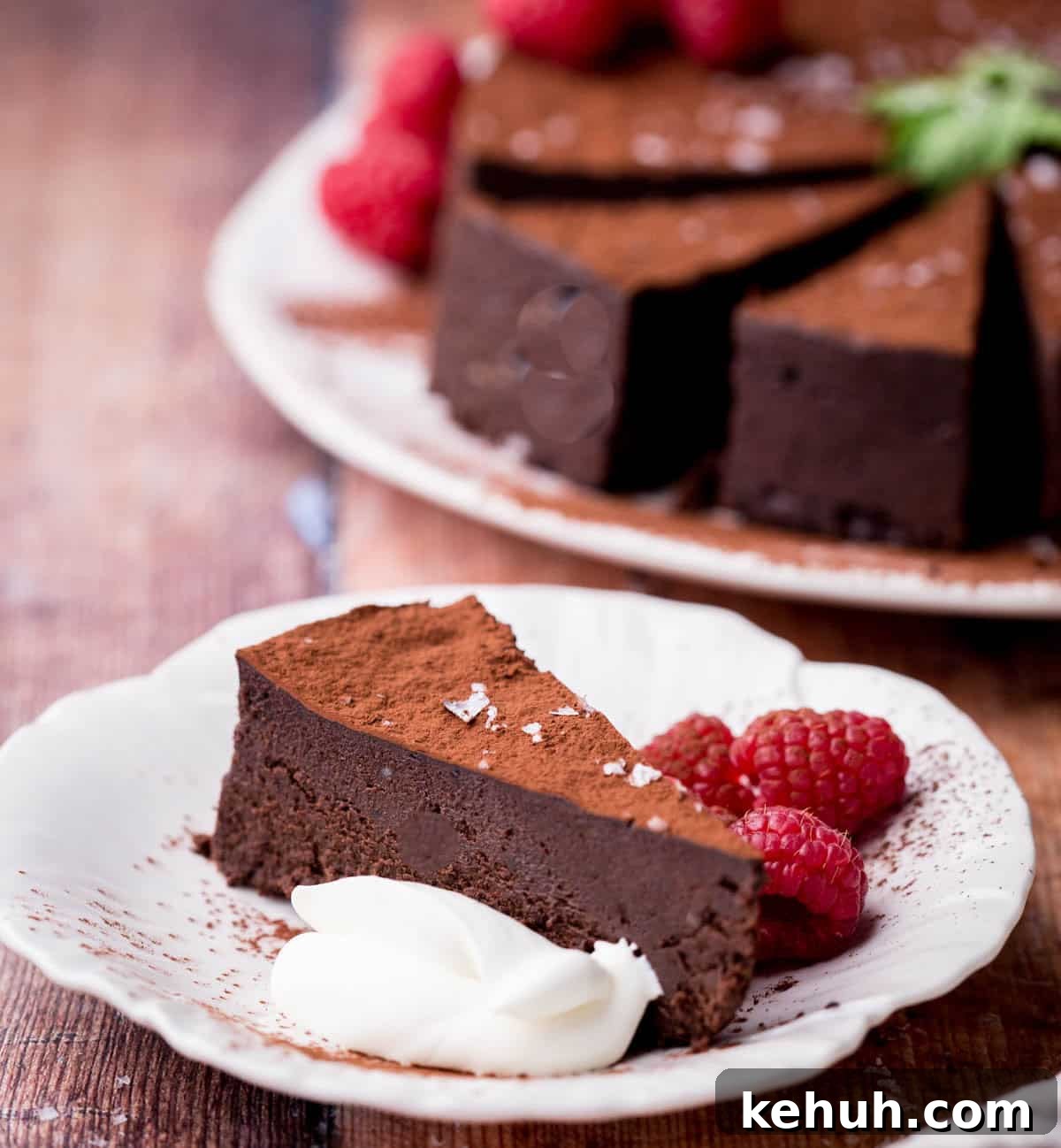 Olive Oil Chocolate Cake (Flourless, Rich & Decadent) 3 Slice of Flourless Olive Oil Chocolate Cake showing fudgy texture next to whipped cream and raspberries.