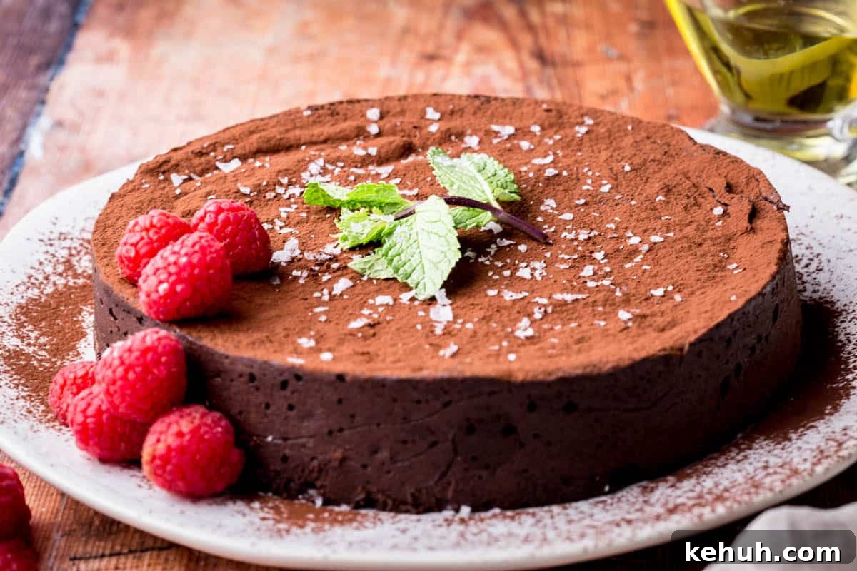 Olive Oil Chocolate Cake (Flourless, Rich & Decadent) 5 Flourless Olive Oil Chocolate Cake dusted with cocoa powder, sprinkled with flaky sea salt and decorated with a mint leaf and raspberries.
