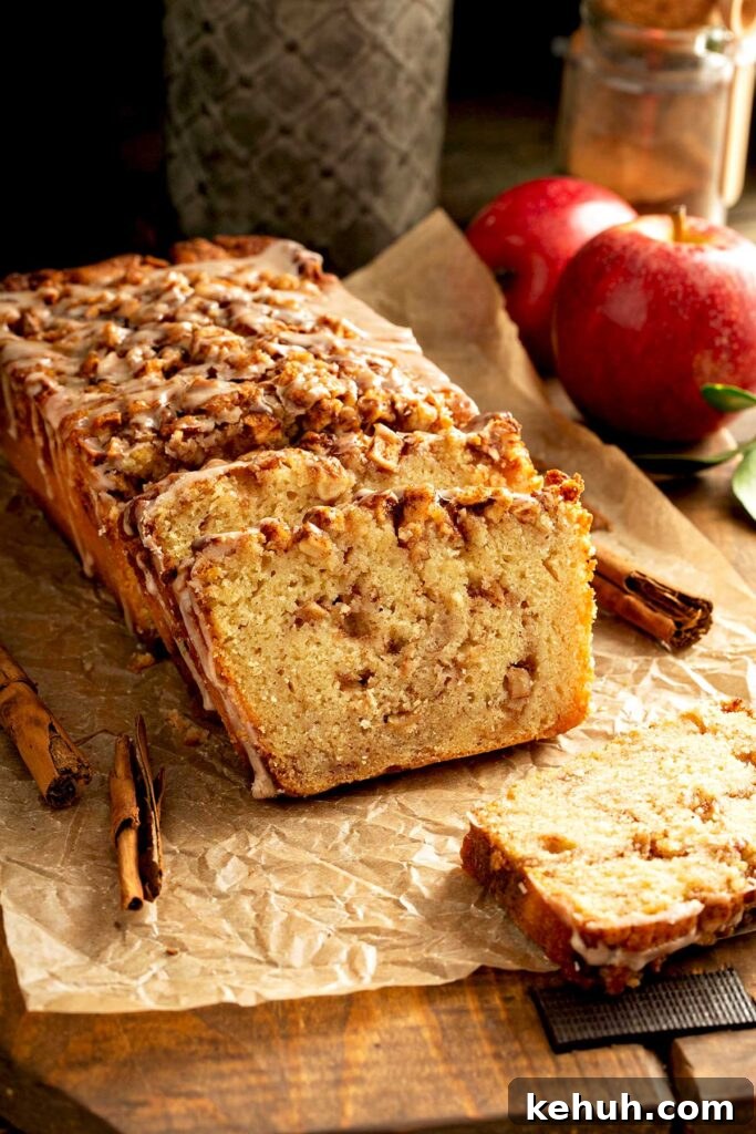 Cinnamon Apple Quick Bread Recipe for Moist, Spiced Loaves 2 Partially sliced homemade apple quick bread with cinnamon sugar streusel and glaze