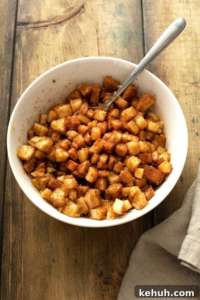 Cinnamon Apple Quick Bread Recipe for Moist, Spiced Loaves 6 Diced apples tossed with brown sugar and cinnamon in a white bowl