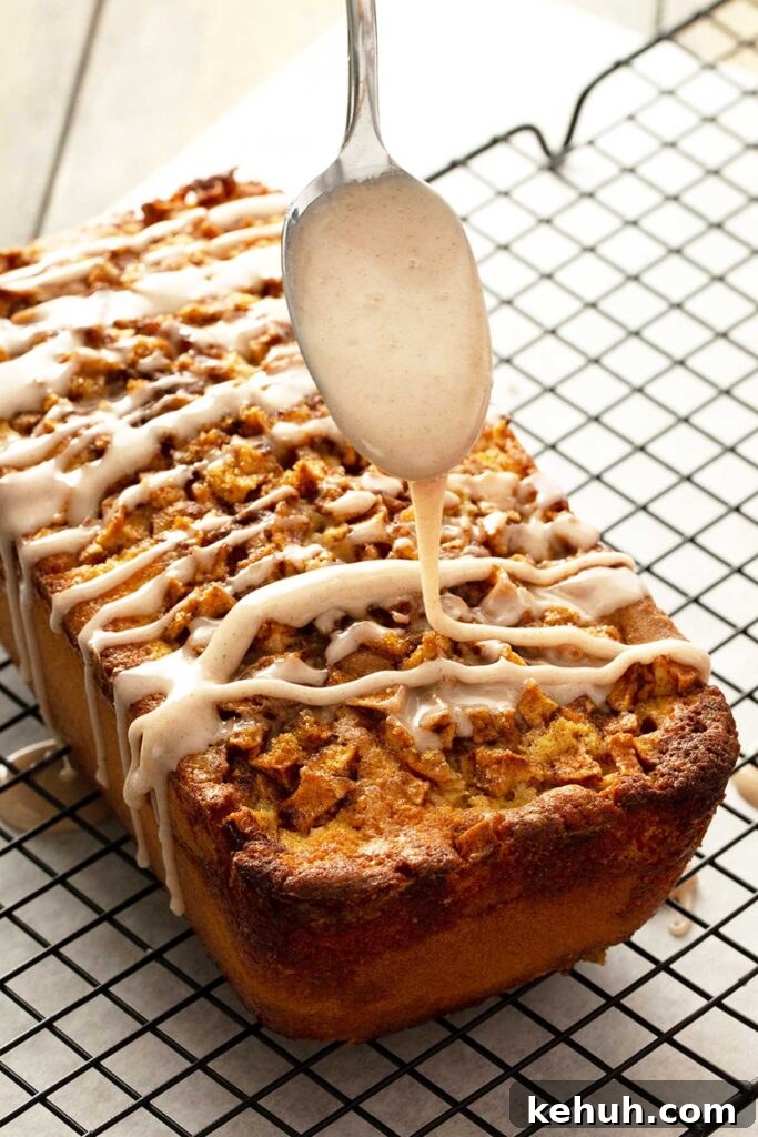 Cinnamon Apple Quick Bread Recipe for Moist, Spiced Loaves 7 A spoon drizzling cinnamon glaze over apple loaf