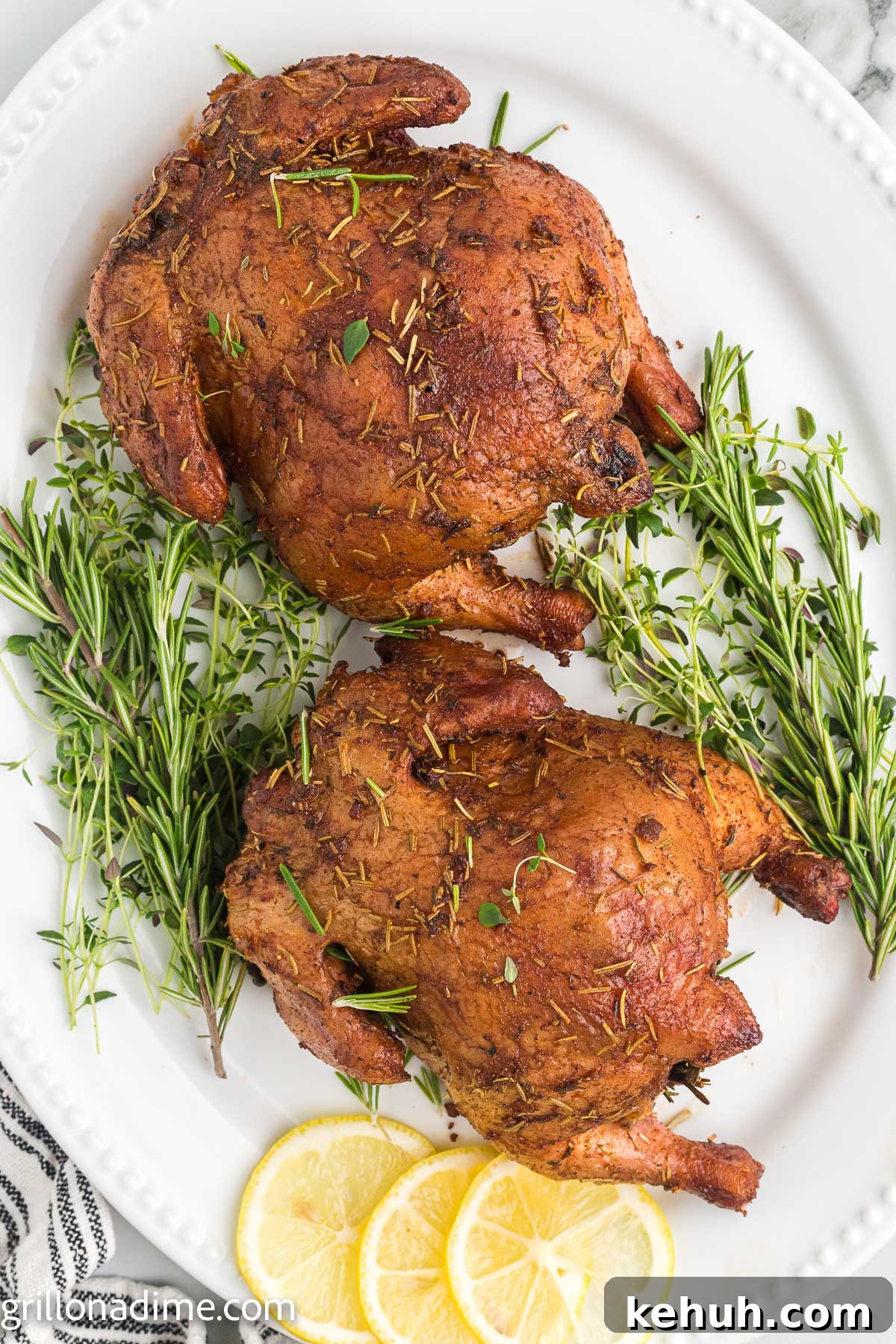 Smoked Cornish Hens Recipe: Juicy, Flavorful Whole Birds 2 Two Cornish Hens on a platter with sprigs of rosemary