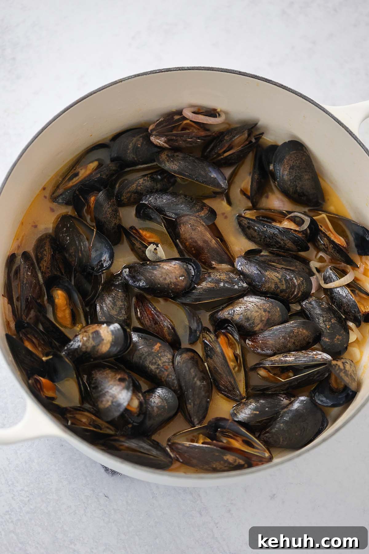 Mussels in Rich Lobster Broth: Savory Seafood Stew Recipe 6 steamed black mussels with lobster broth in a pot.