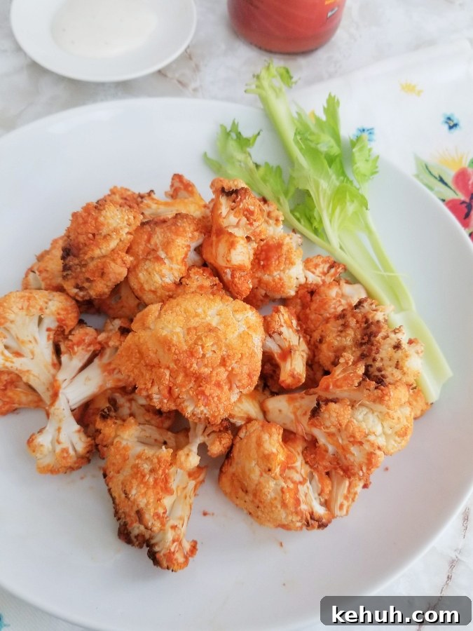Crispy Air Fryer Buffalo Cauliflower Bites Recipe 7 Air Fryer Buffalo Cauliflower on white plate with celery