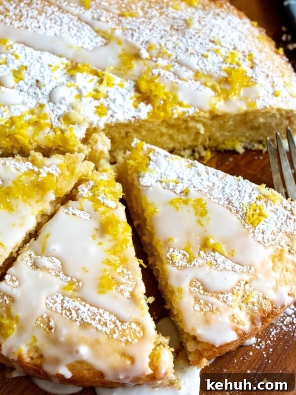 Cake with lemon zest on a cutting board.