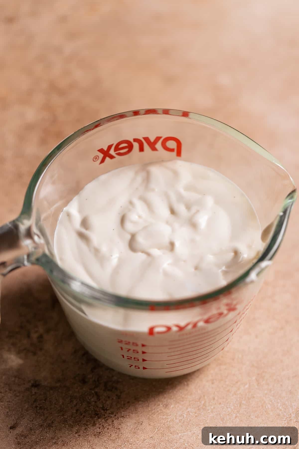 A glass measuring cup full of marshmallow glaze.