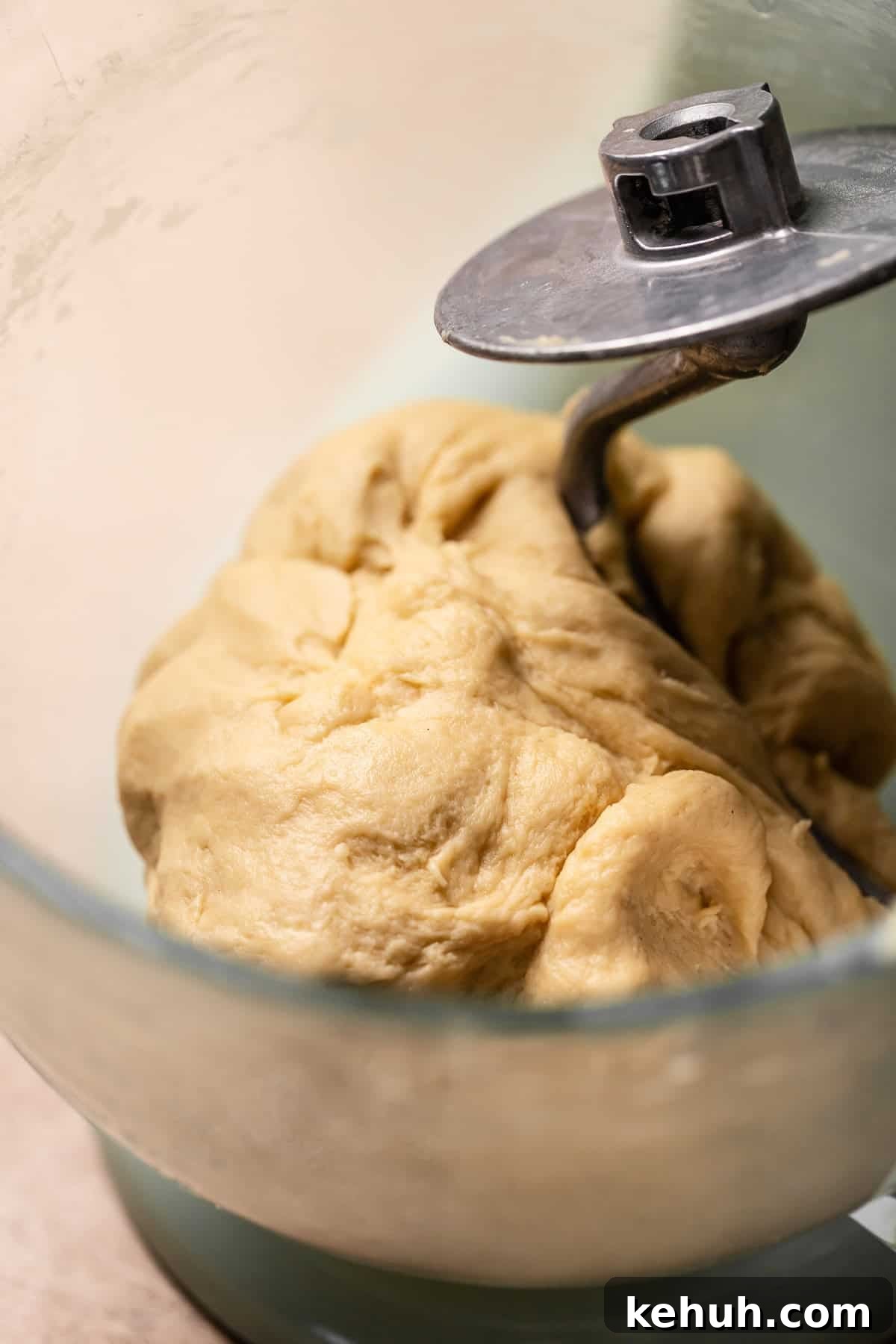 Smooth dough ball in a glass mixer bowl.