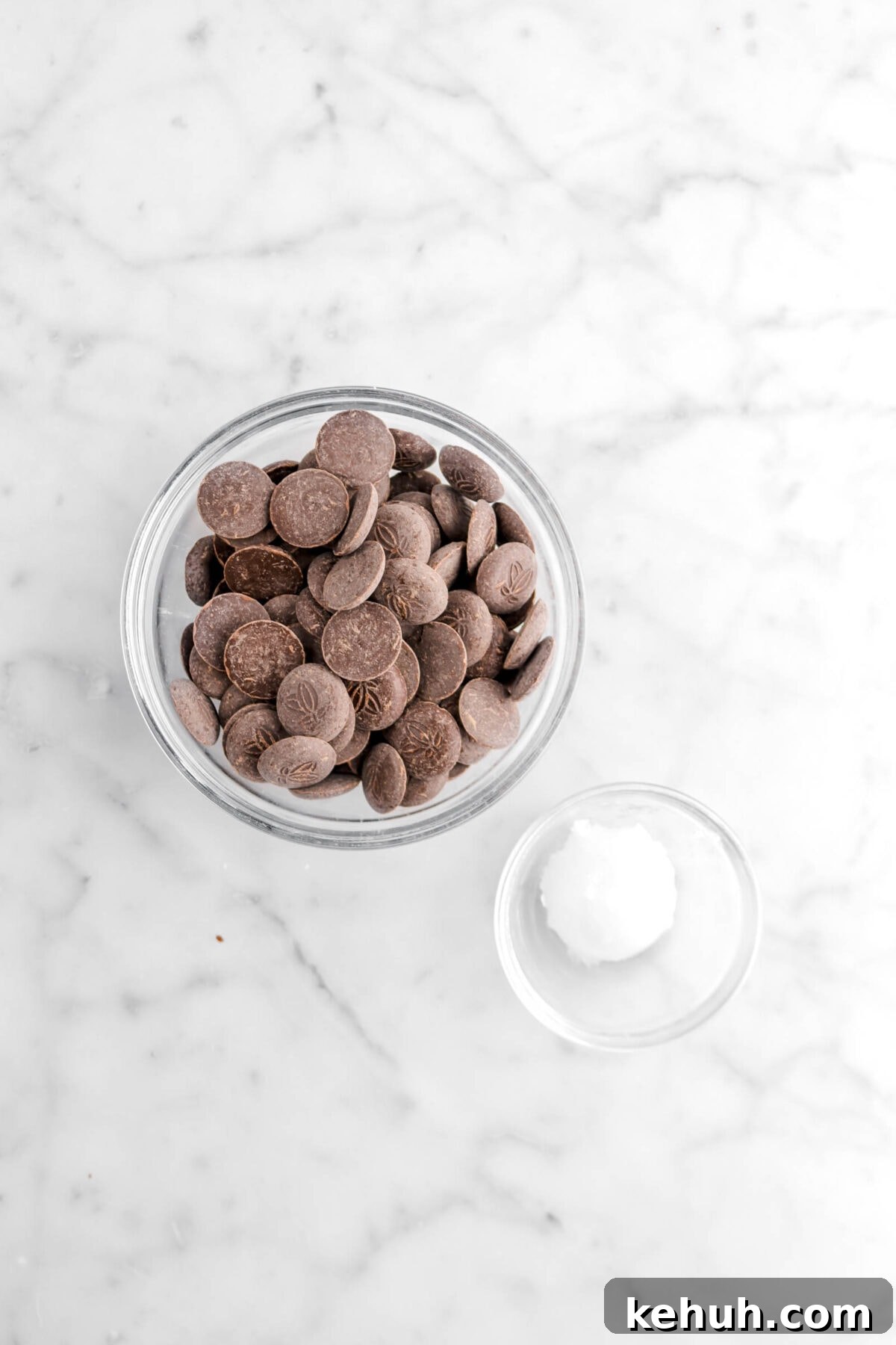 Coconut Cream-Filled Chocolate Truffles: Decadent Homemade Recipe 8 chocolate discs and coconut oil in glass bowls on marble surface