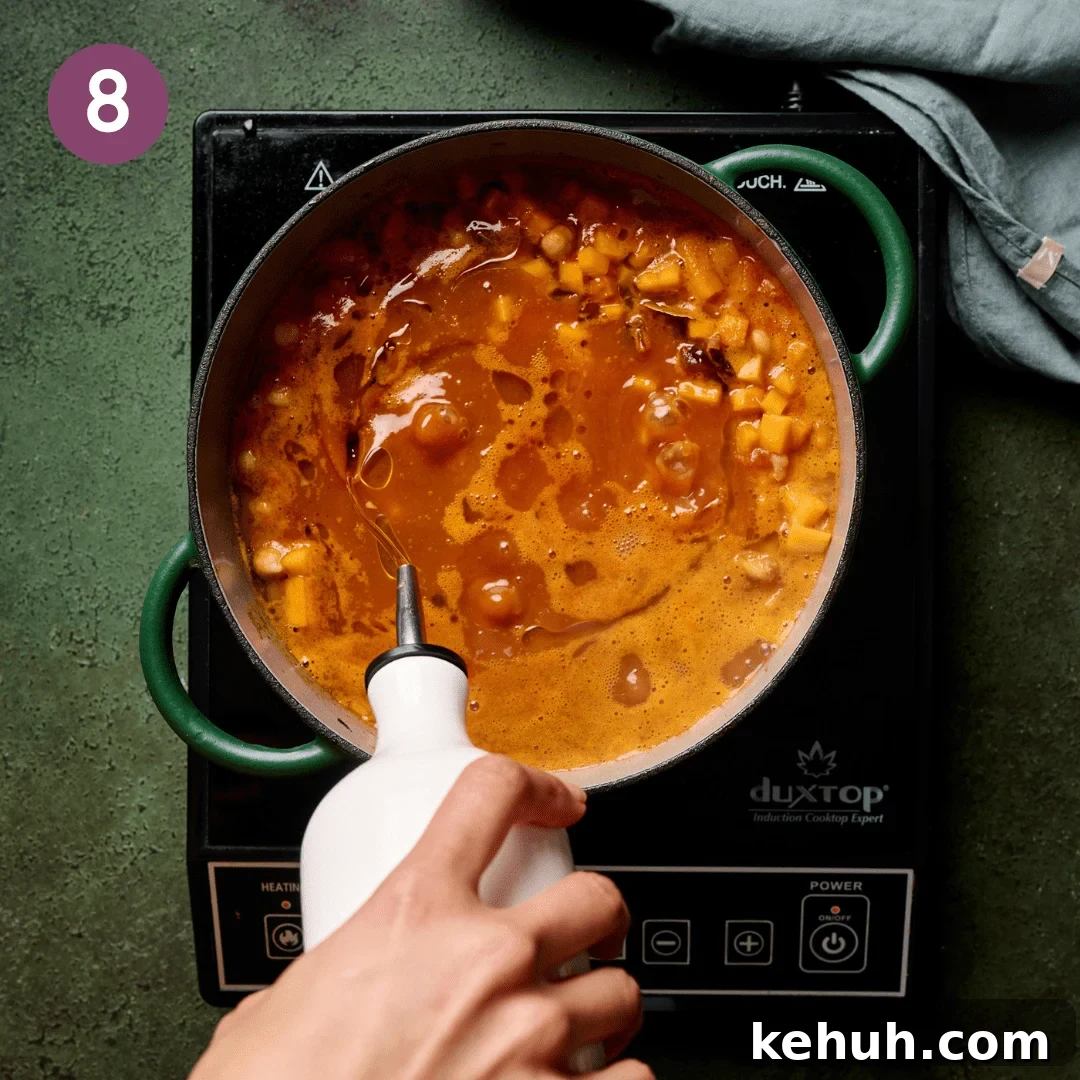 Person stirring the pot after a glug of olive oil is added.