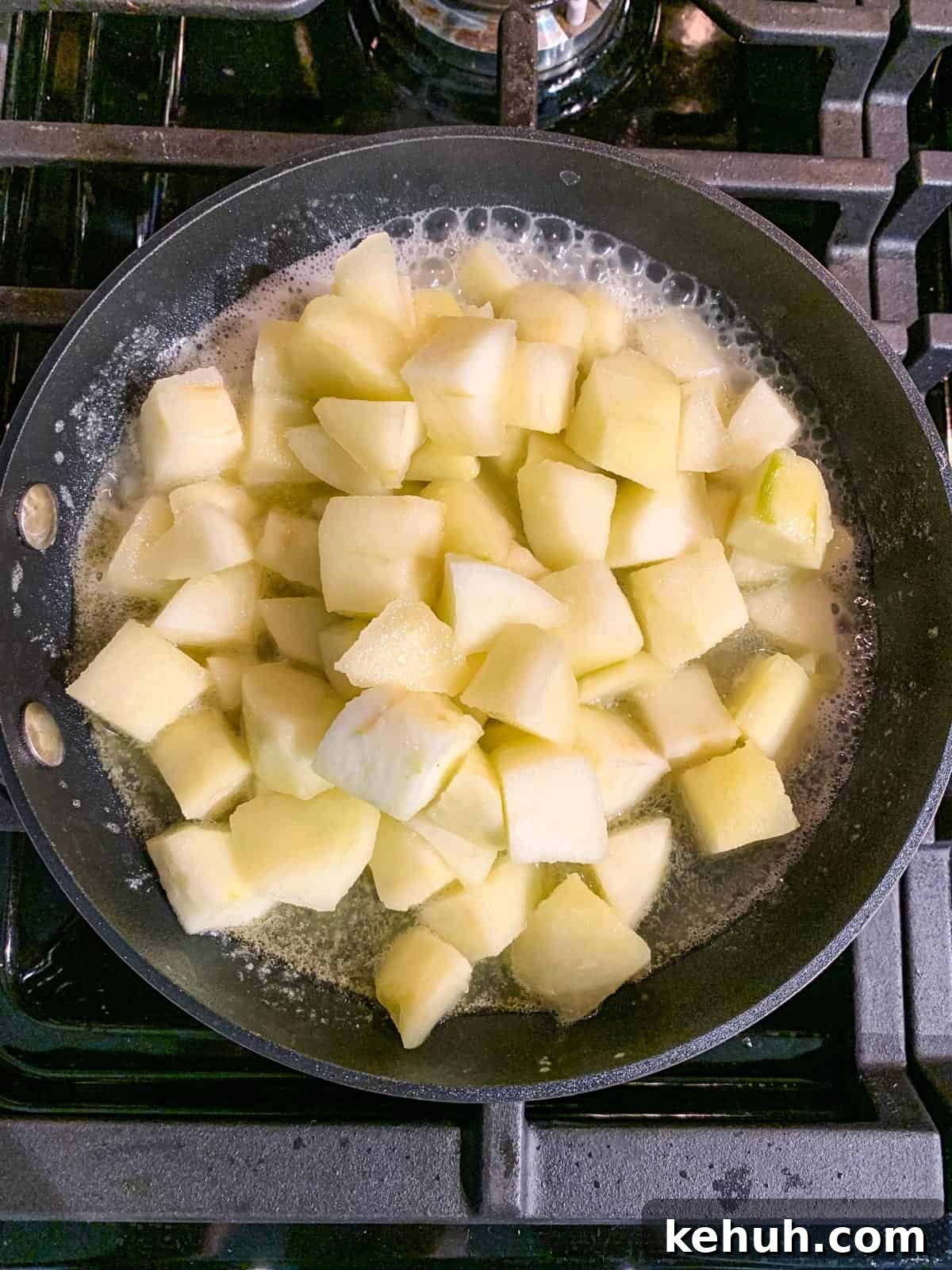 Stovetop Cinnamon Apples Recipe — Quick Comfort Dessert 5 Diced apples simmering in a skillet.