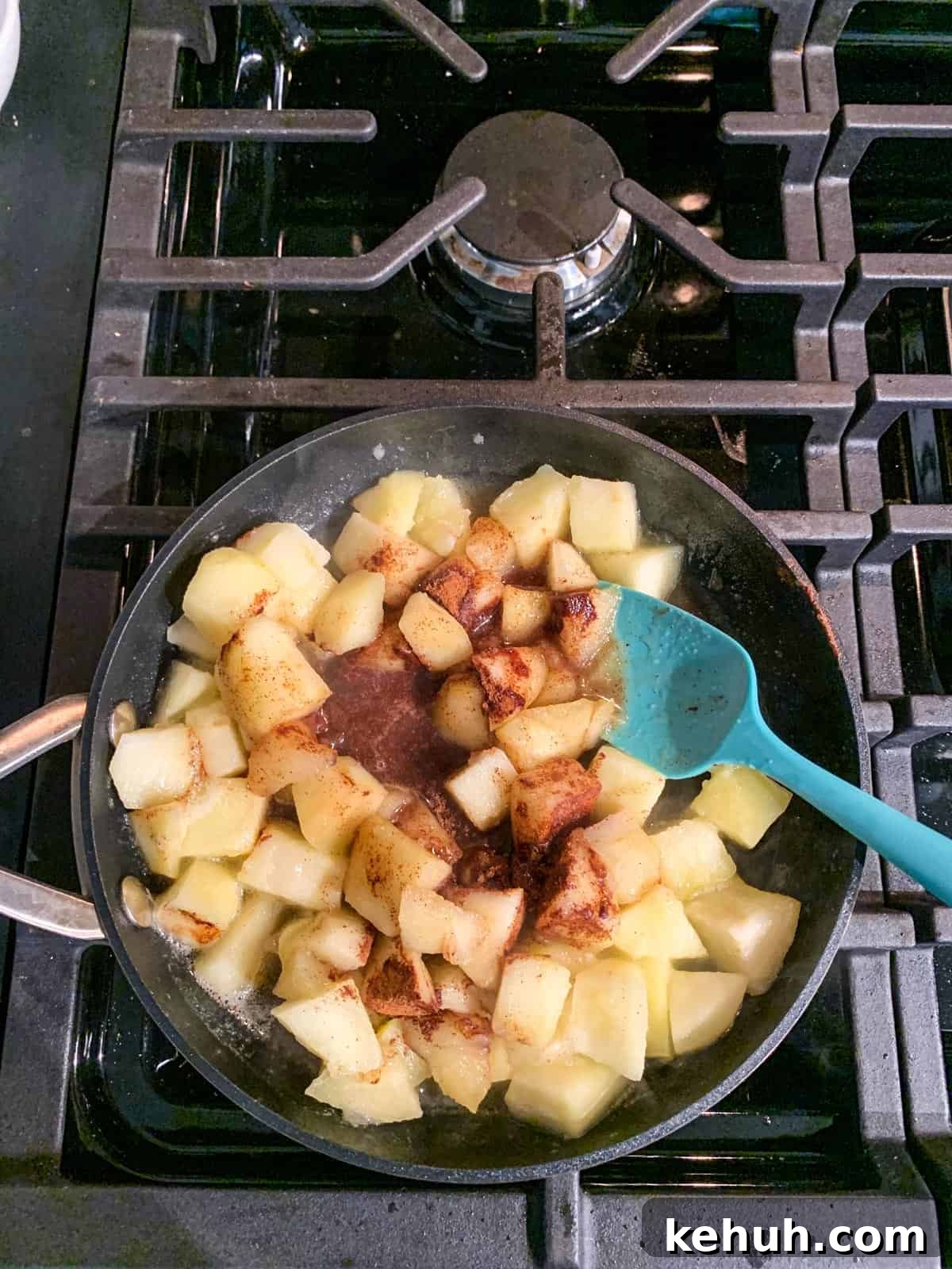 Stovetop Cinnamon Apples Recipe — Quick Comfort Dessert 6 Cinnamon and maple syrup added to a skillet of diced fruit.