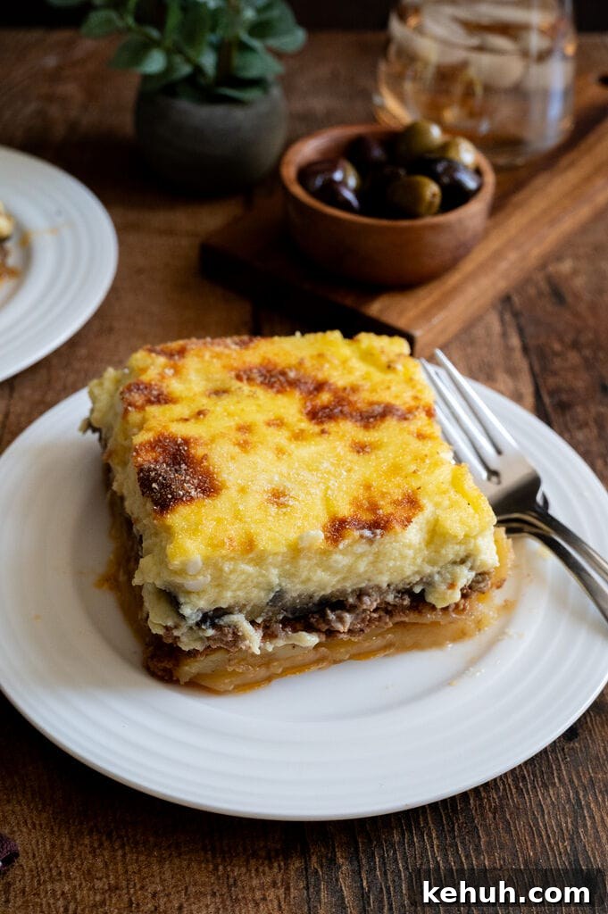 A piece of moussaka on a white plate.